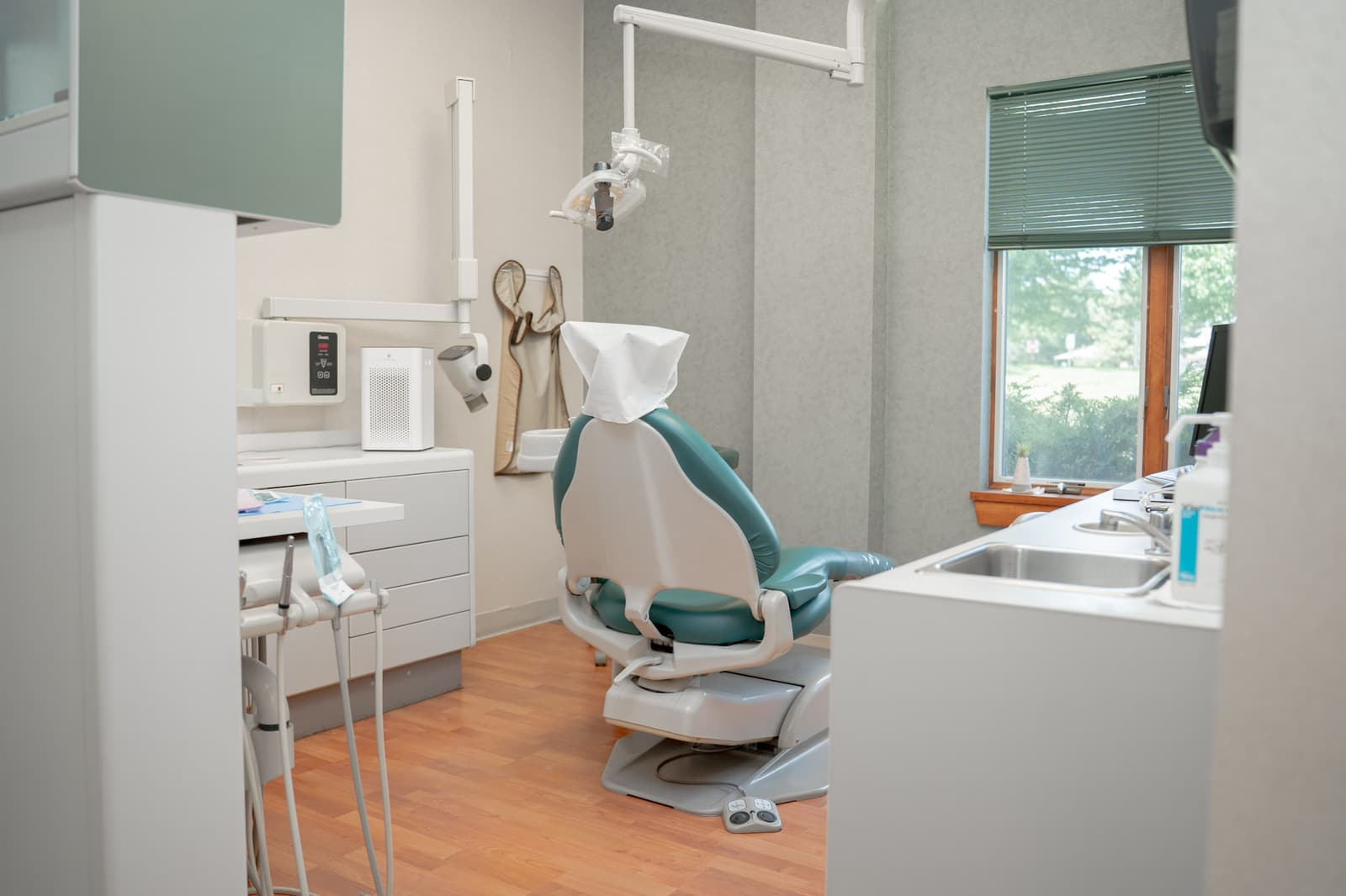 Treatment room with a dental chair beside a window
