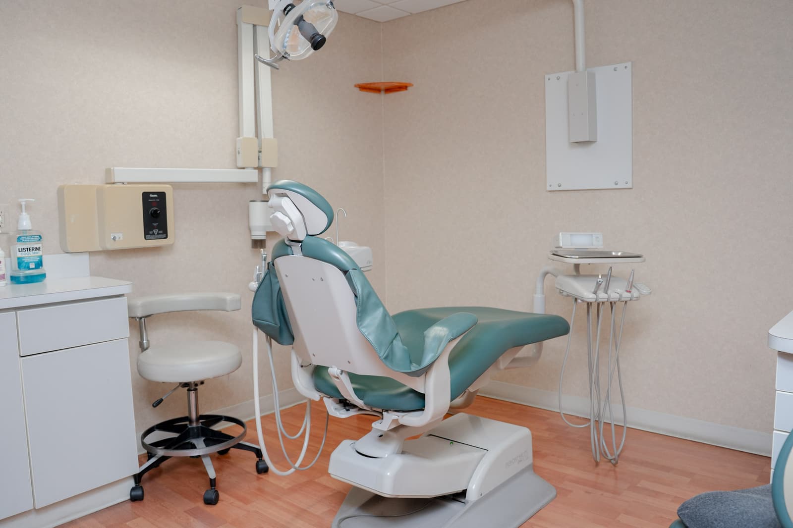 Private treatment room with a dental chair and stool